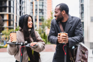Couple avec café et trottinettes électriques