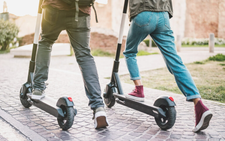 Couple trottinette électrique sur pavés