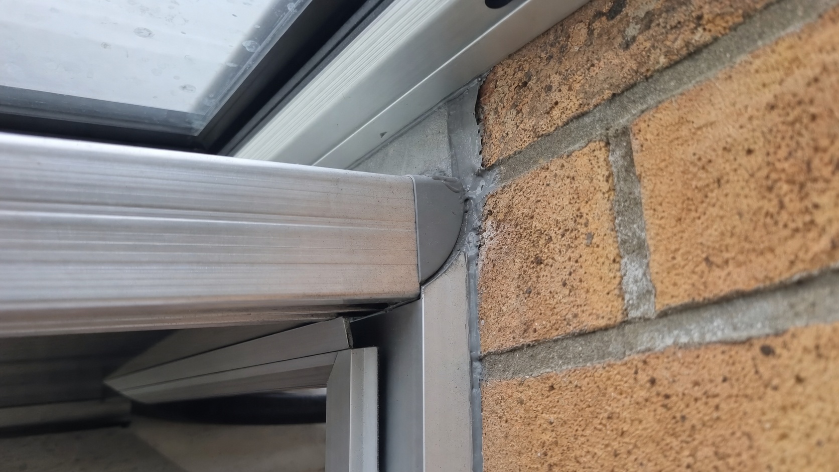 Détail de profilé aluminium et joint d'étanchéité sur une véranda en cours de pose