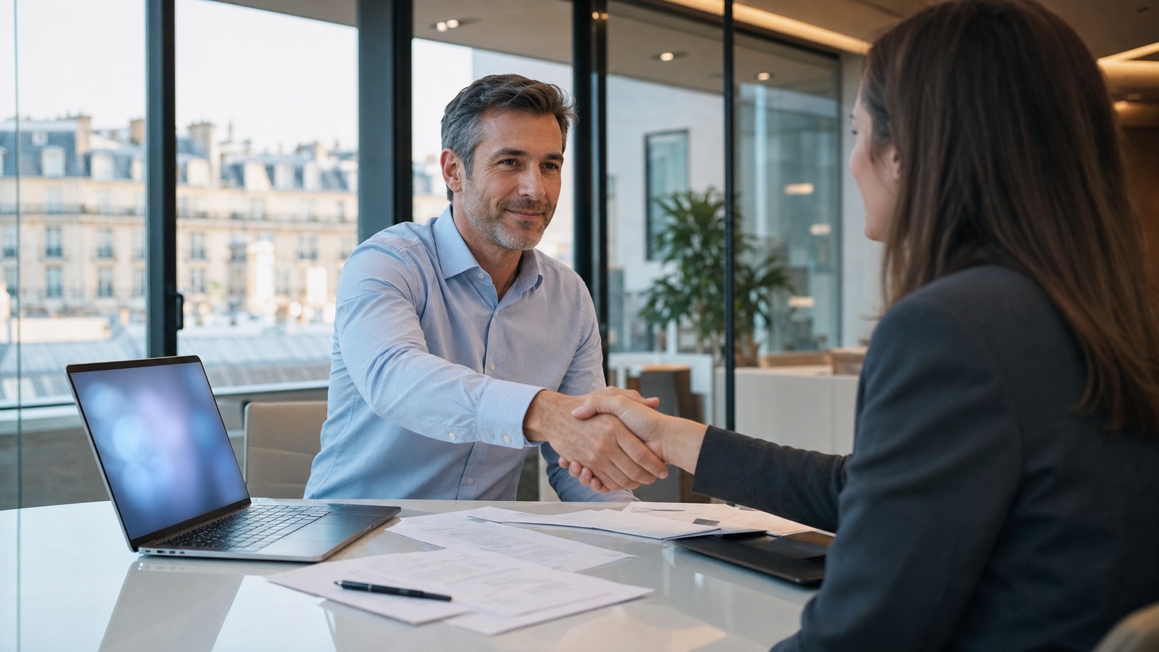 Consultant IT et client signant un contrat de prestation sur une table de réunion dans un bureau d'entreprise à Paris
