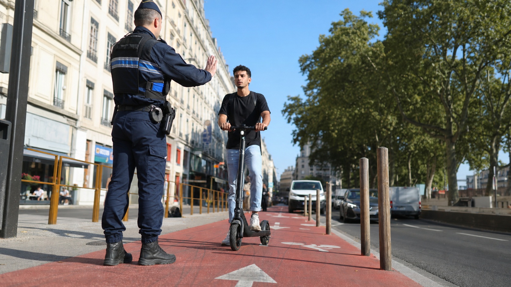 Utilisateur de trottinette électrique contrôlé par un agent de police sur une piste cyclable urbaine à Lyon